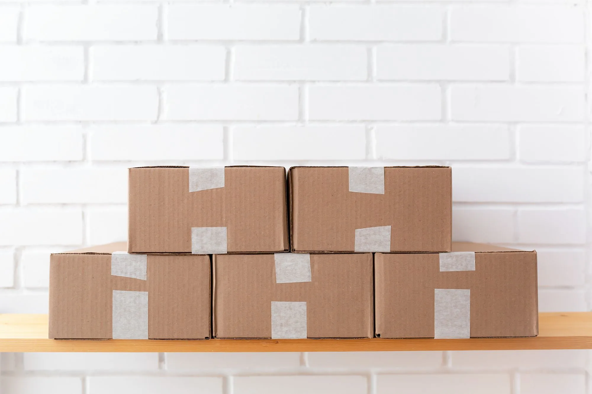 Corrugated cartons sealed with strips of paper-based tape
