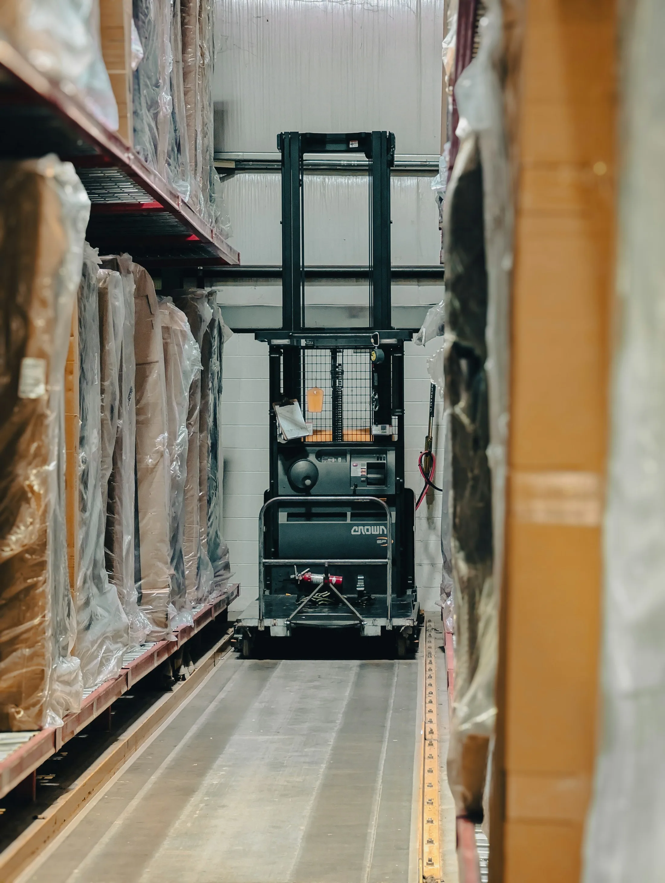 Forklift between wrapped warehouse inventory